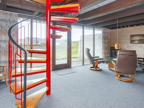 A modern interior with a spiral staircase, a seating area with a table, and a view through large windows. - Scenic Holiday Home in Harboøre near Sea (Harboore)