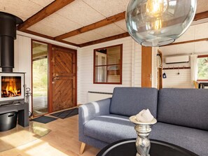 A cozy living room with a fireplace, a sofa, and a table with a decorative item.