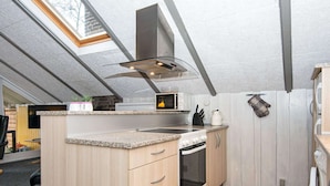 Et moderne køkken med ovenlys, indbygget ovn og mikroovn.