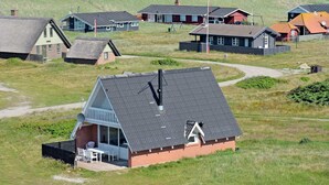 En kustby med traditionella hus, en liten byggnad med ett sluttande tak och en fri utsikt över havet.