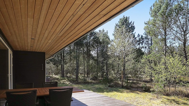A covered outdoor area with a wooden deck, a table, and chairs. - Peaceful Holiday Home in Nordjylland With Sauna (Læsø)