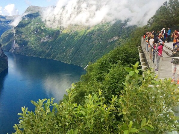 A scenic overlook with a crowd of people, overlooking a deep blue lake and lush green mountains. - Holiday Home in EidsvÃ¥g (Molde)