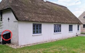 A traditional thatched-roof cottage with a white exterior, a small porch, and a single visible window. - 4 Star Holiday Home in Ribe (Ribe)