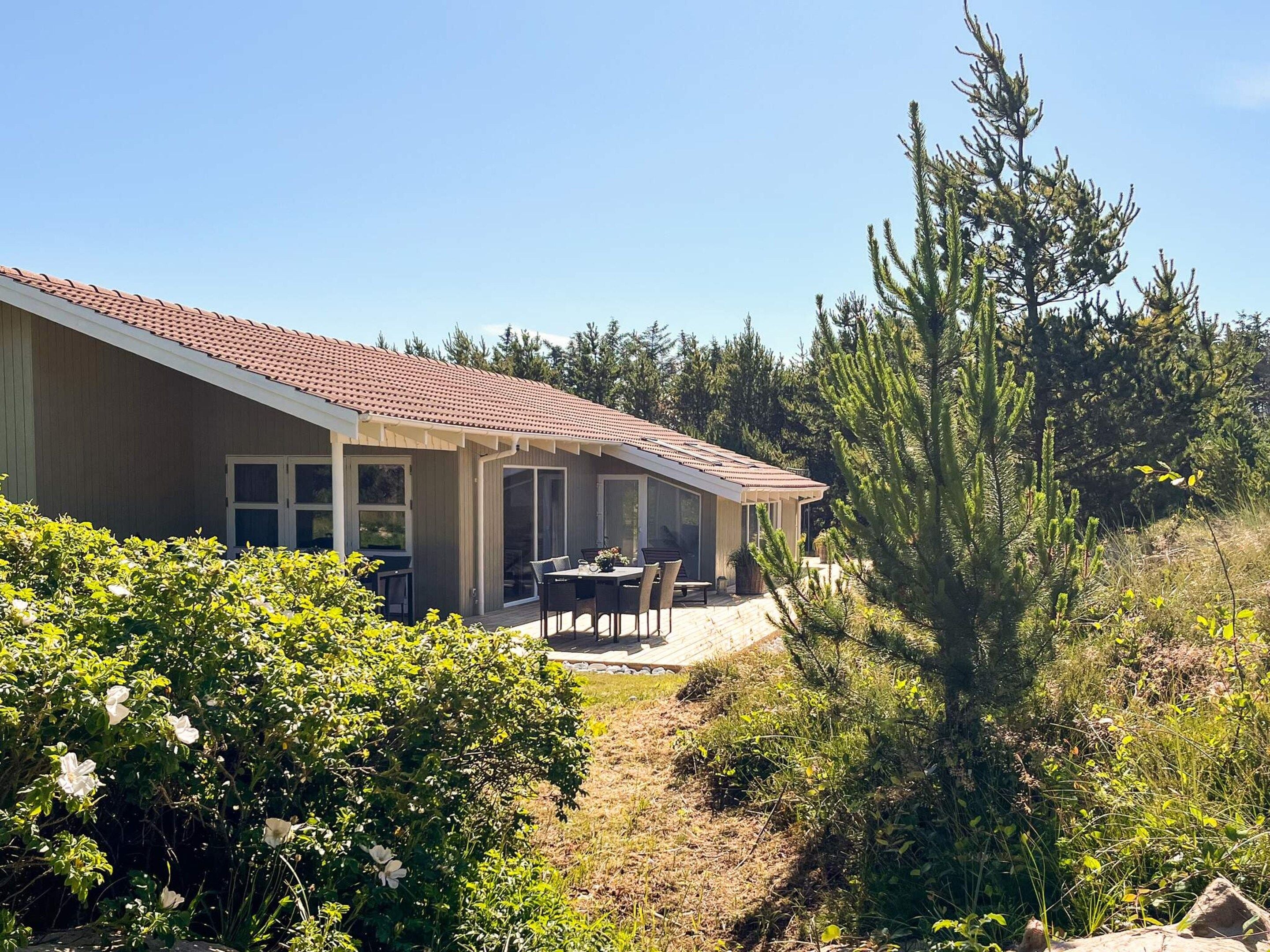 A house with a patio, a dining table, and chairs.
