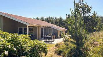 A house with a patio, a dining table, and chairs.
