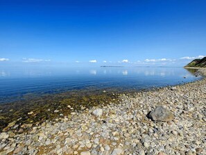 A clear lake with a rocky shoreline and distant land. - 4 Star Holiday Home in Fur (Fur)