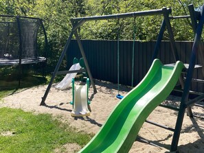 A playground with a swing set and two slides. - 4 Star Holiday Home in Oksbol (Oksbol)