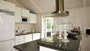 A modern kitchen with white cabinets, a granite countertop, a stainless steel range hood, and a coffee machine. - Cozy Holiday Home in Hadsund near Family Friendly Beach (Hadsund)