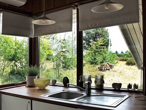 Enjoy a serene view of the lush garden from this kitchen's large window.