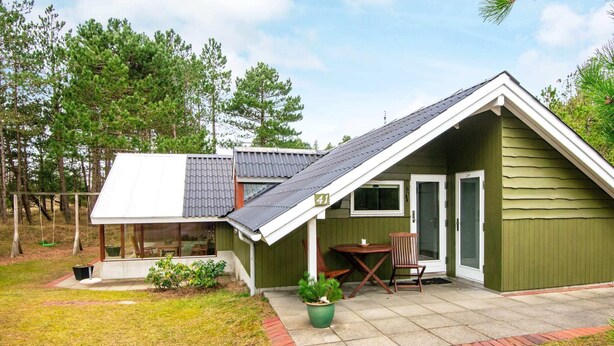 A small, single-story house with a sloped roof, a covered porch, and a patio area. - 5 Person Holiday Home in Romo (Rømø)