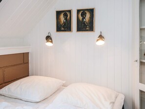 A bedroom with two beds, white walls, wooden headboard, and two wall-mounted lights. - 6 Person Holiday Home in Ringkobing (Ringkobing)