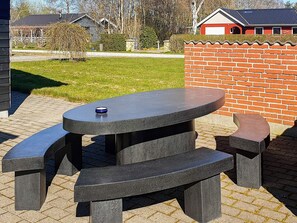 Ett bord och bänkar i sten, placerade i ett vackert utomhusområde.