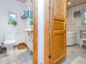A modern bathroom with a toilet, sink, and bathtub. - 8 Person Holiday Home in Jaegerspris-by Traum (Jægerspris)
