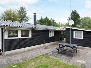 Un bâtiment à deux étages, doté d’un toit recouvert de tuiles, d’une cheminée et d’une antenne parabolique.