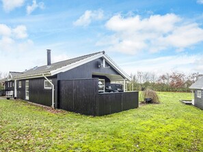 A two-story house with a covered patio area, a chimney, and a fenced yard. - 4 Star Holiday Home in Tarm (Tarm)