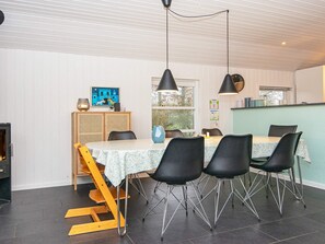 A dining area with a table set for four, black chairs, a wooden chair lift, and pendant lights. - 4 Star Holiday Home in Tarm (Tarm)