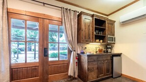 Une cuisine avec des meubles de rangement en bois, un four à micro-ondes et une machine à café.
