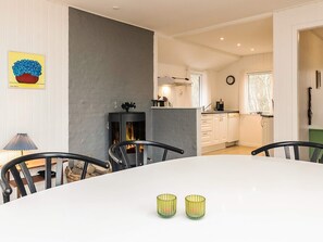 A dining area with a white table, two chairs, and two glass candle holders. - 4 Star Holiday Home in Hadsund (Hadsund)