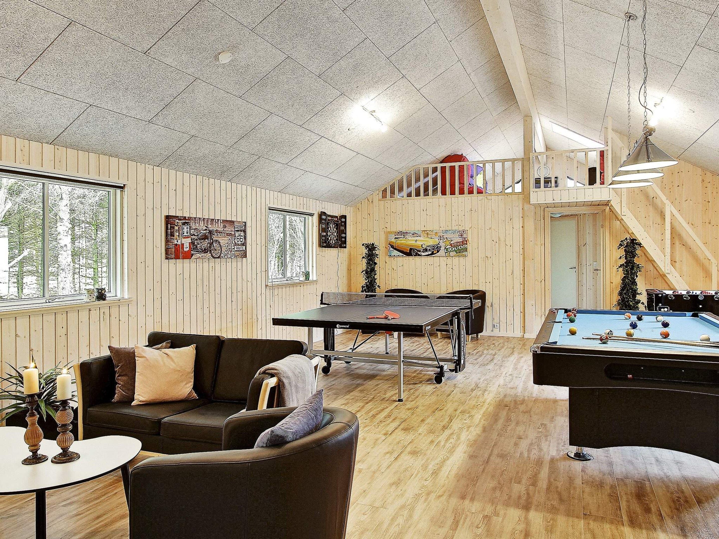 Une pièce confortable avec une table de billard, un canapé et une table de ping-pong.