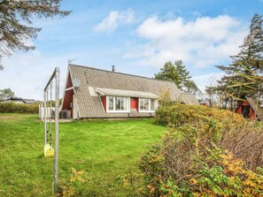 A house with a sloped roof, a satellite dish, and a well-maintained lawn.