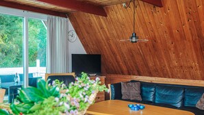 A cozy living room with a wooden ceiling, a sofa, a coffee table, and a television. - 4 Person Holiday Home in Romo (Rømø)