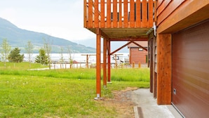 A wooden building with a balcony overlooking a grassy area and a body of water. - Holiday Home in Eidsvåg (Molde)