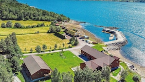 A lakeside property with multiple buildings, a dock, and a view of the lake and mountains. - Holiday Home in Eidsvåg (Molde)