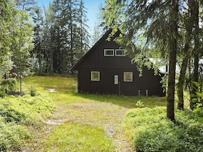 A rustic cabin with a sloped roof, surrounded by dense forest. - 5 Person Holiday Home in Logdea (Lögdeå)