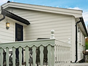 A white building with a balcony and a black door. - Holiday Home in Austrheim (Austrheim)