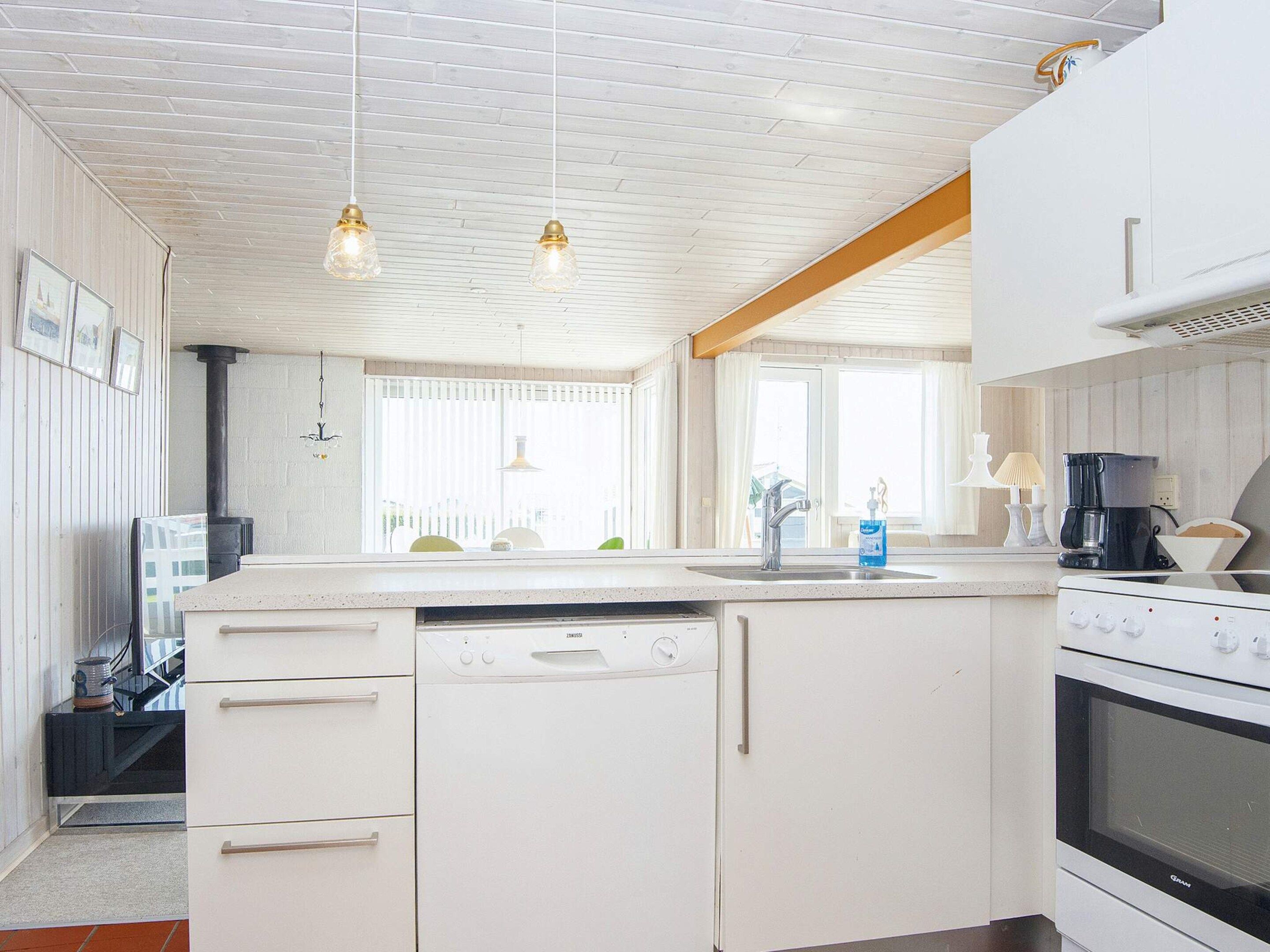 A kitchen with white cabinetry, a dishwasher, an oven, and pendant lighting.