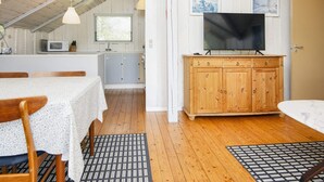 A cozy room with a dining table, wooden cabinets, and a television. - 4 Person Holiday Home in Oksbol (Oksbol)