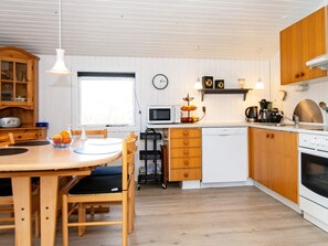 A modern kitchen with wooden cabinets, a microwave, a dishwasher, and a stove.