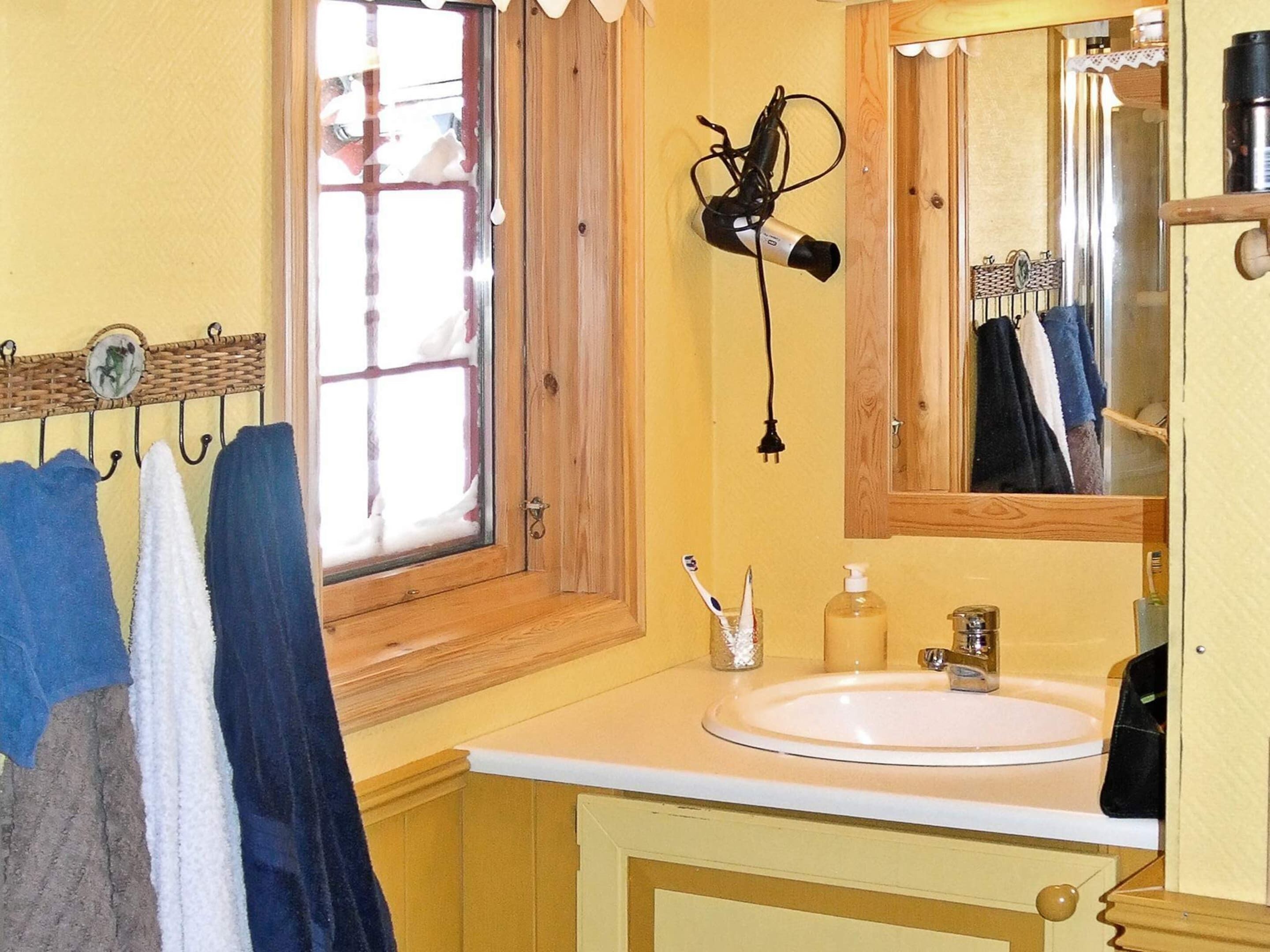 A bathroom with a sink, mirror, and towel rack.