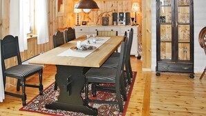 A wooden dining room with a long table, chairs, a chandelier, and a cabinet with glass doors. - 11 Person Holiday Home in Edland (Vinje)