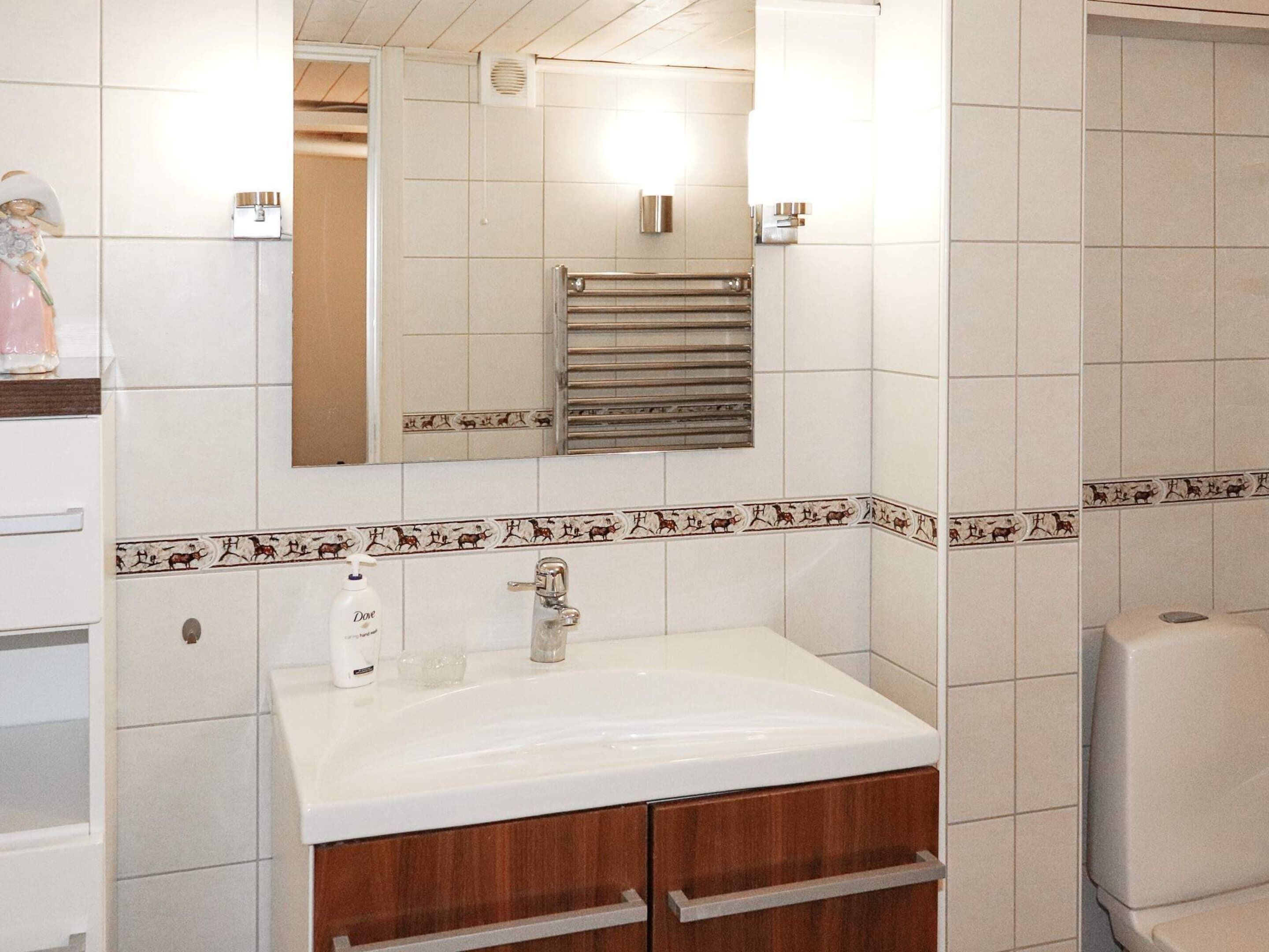A bathroom with a white sink, a mirror, and a towel rack.
