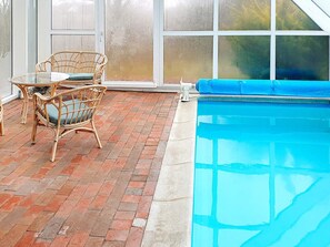 A pool area with a brick floor, wicker furniture, and a blue pool. - 6 Person Holiday Home in Farso (Farso)