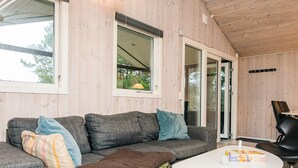 A modern living room with a grey sofa, a white coffee table, and a black chair. - Rustic Holiday Home in Ansager near Water (Ansager)
