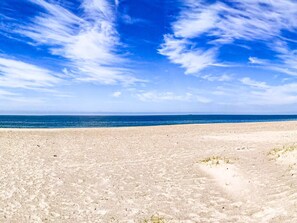 Une plage avec un ciel dégagé et une mer calme.