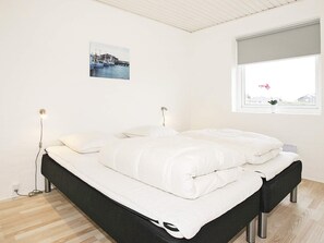 A bedroom with a bed, bedside lamps, a window with a view, and a picture on the wall. - 5 Star Holiday Home in Harboore (Harboore)