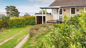 Een huis met een overdekte veranda, een duidelijke deur en een pad naar de ingang.