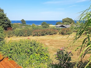 Une propriété située sur la côte, dotée d’une pelouse verdoyante, d’une végétation luxuriante et offrant une vue sur la mer.