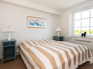 A bedroom with a bed, two bedside tables, a window with a view, and a framed picture on the wall. - 6 Person Holiday Home in Aabenraa (Aabenraa)