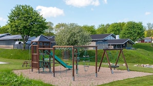 A playground with climbing structures and swings. - 6 Person Holiday Home in Aabenraa (Aabenraa)