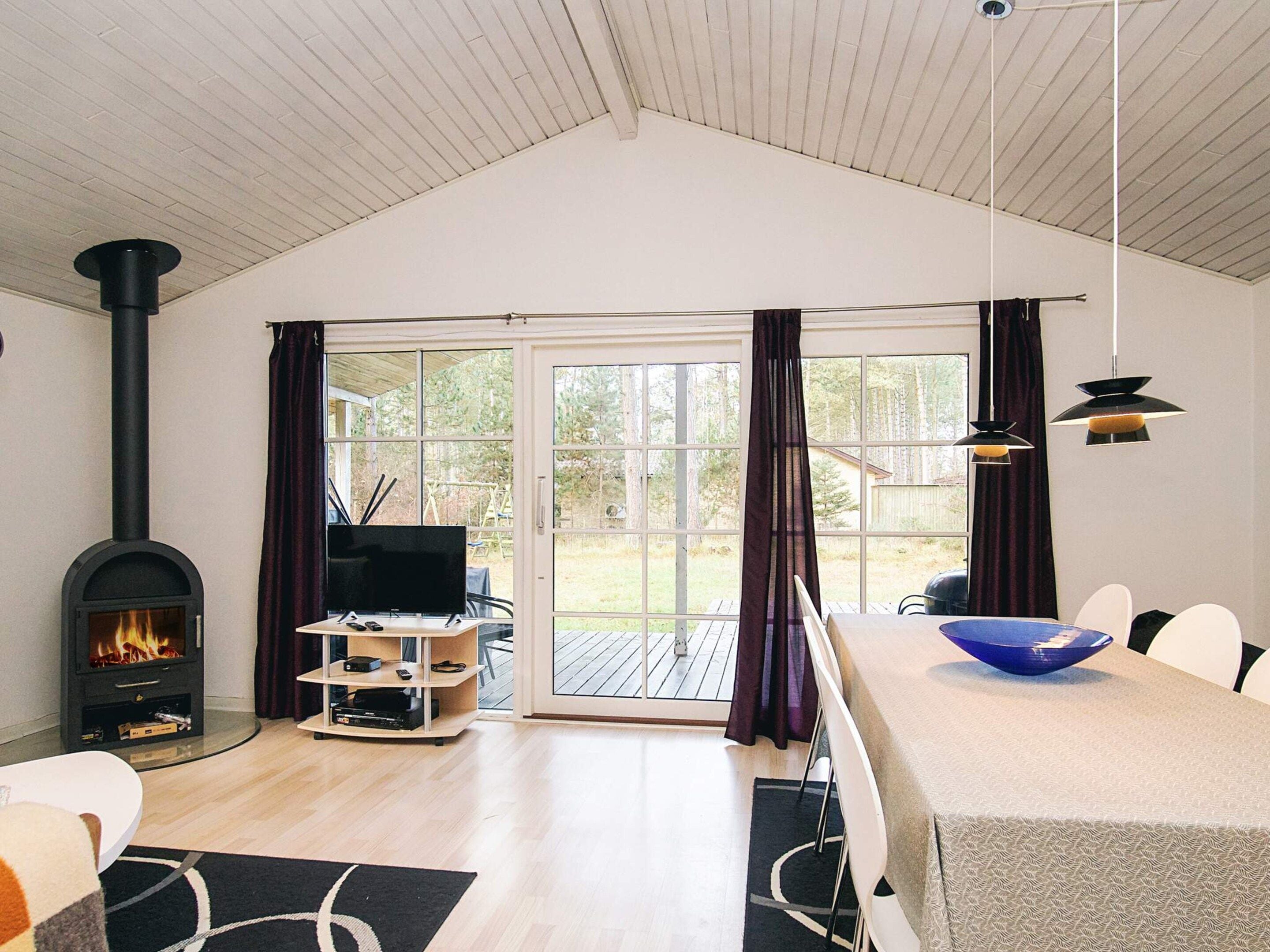 A living room with a fireplace, television, and a dining area with a large bowl.
