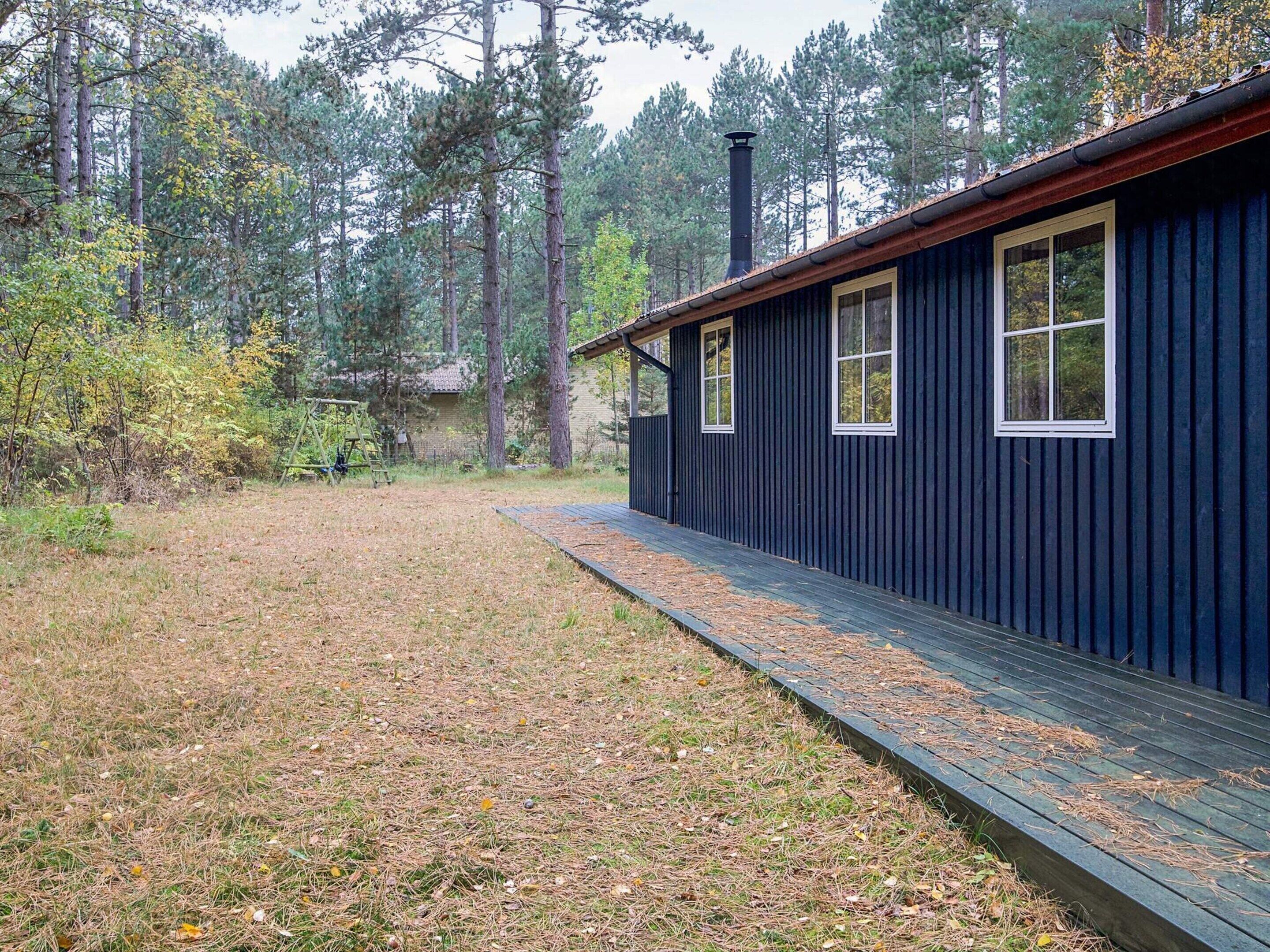 A cabin with a wooden deck and a chimney.
