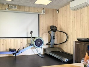 Kuntosali, jossa on soutulaite, kuntopyörä ja juoksumatto.