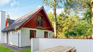 Une cabane rouge et blanche avec un banc en bois devant.
