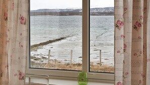 Ein Fenster mit Blick auf einen See und eine entfernte Uferlinie.