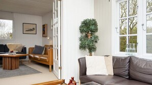 Un salon avec un canapé en cuir marron, une table basse en bois et une plante en pot.