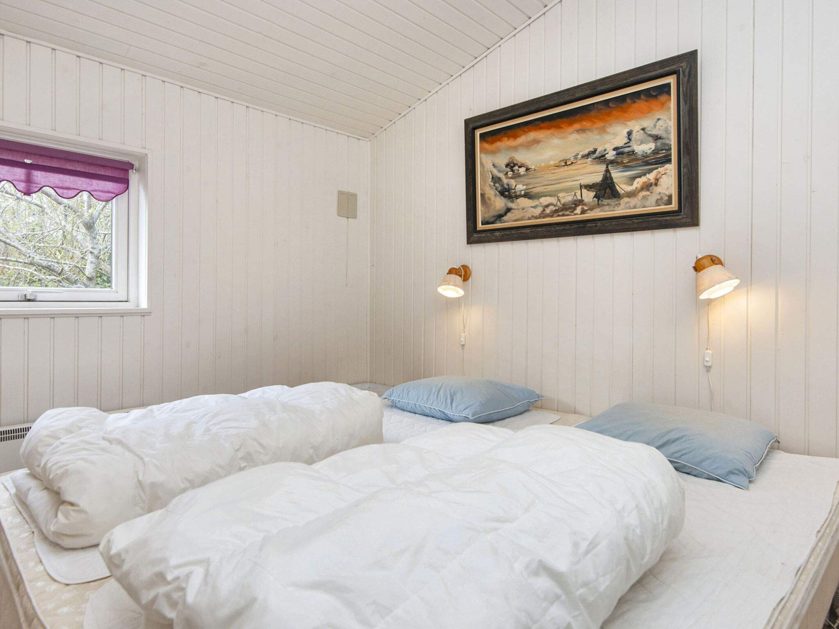 Ein Zimmer mit zwei Betten, einem Fenster mit violettem Vorhang und einem Bild an der Wand.